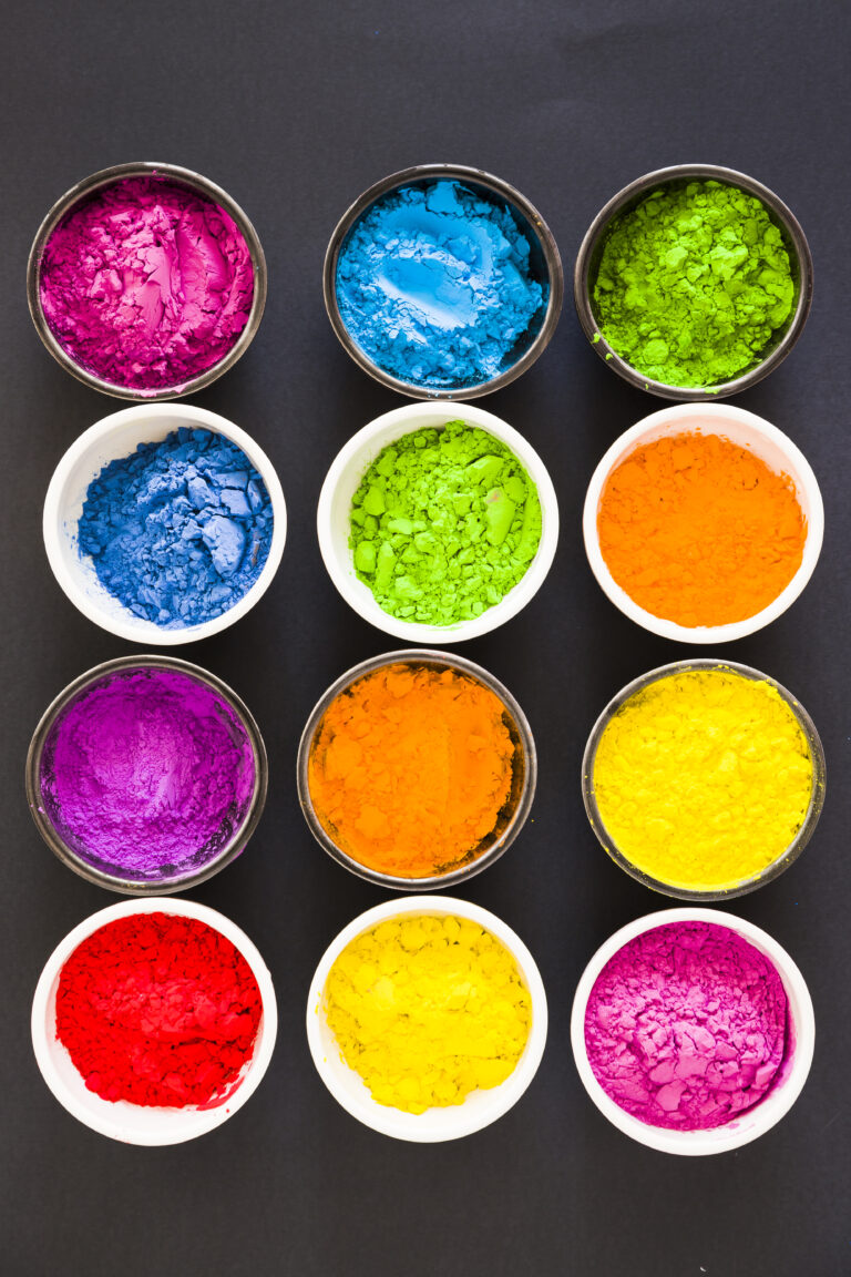 various colorful holi color powder bowls black background